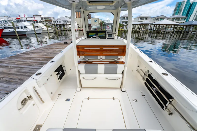 Slide: The Image of 2021 Pursuit S 288 Sport boat interior at a marina, showcasing seating and docked boats. - 29