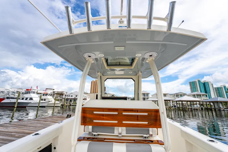 Slide: The Image of 2021 Pursuit S 288 Sport boat interior at marina, showcasing seating and helm features. - 30