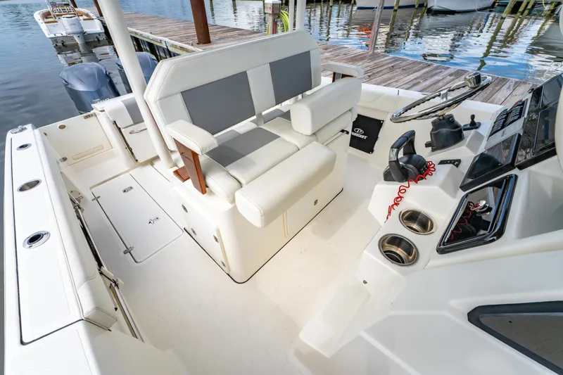 Slide: The Image of 2021 Pursuit S 288 Sport boat interior with helm, seating, and docked at marina. - 31
