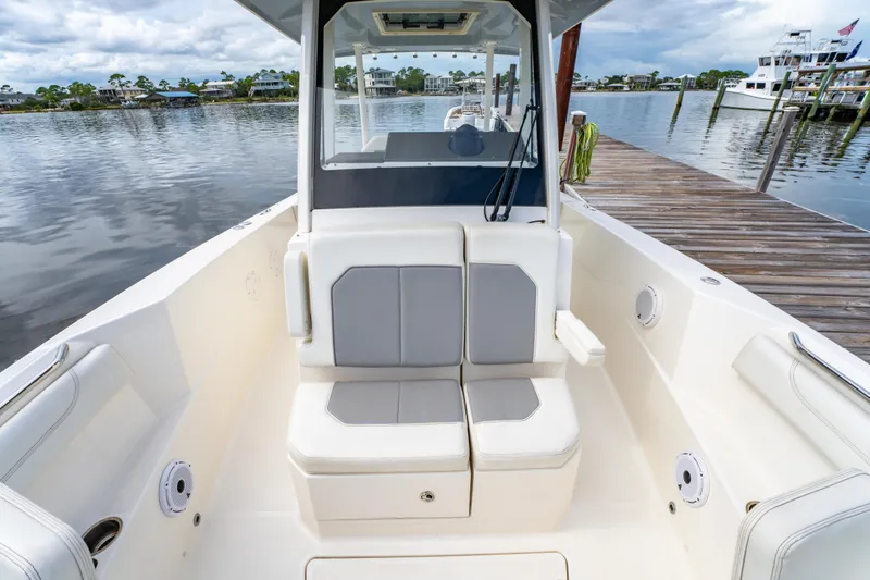 Slide: The Image of 2021 Pursuit S 288 Sport boat interior with seating, docked by calm waters. - 34