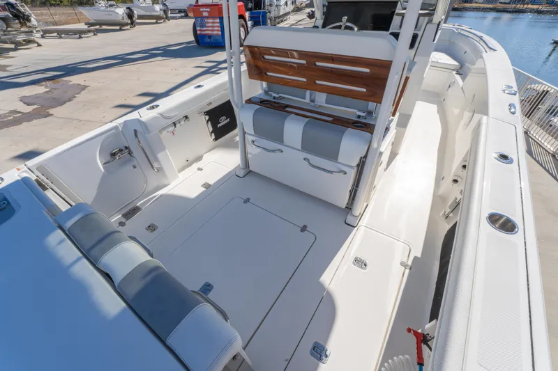 Slide: The Image of 2021 Pursuit S 288 Sport boat interior with seating and storage, docked at marina. - 43