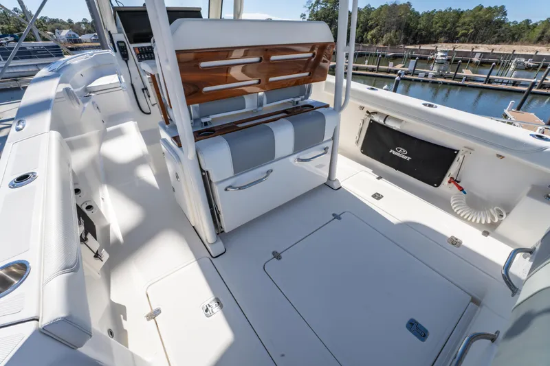 Slide: The Image of 2021 Pursuit S 288 Sport boat interior with seating and storage at a marina. - 45