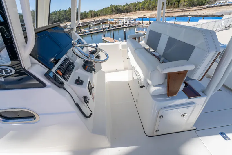 Slide: The Image of 2021 Pursuit S 288 Sport boat interior with helm and seating, dockside view. - 48