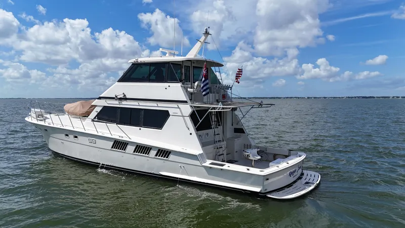 Slide: The Image of 1988 Hatteras Enclosed Bridge Sportfish yacht on open water under a blue sky. - 1