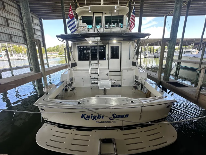 Slide: The Image of 1988 Hatteras Enclosed Bridge Sportfish docked in a marina, rear view. - 16