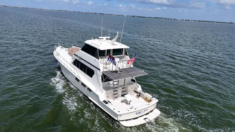 Slide: The Image of 1988 Hatteras Enclosed Bridge Sportfish yacht cruising on open water. - 2