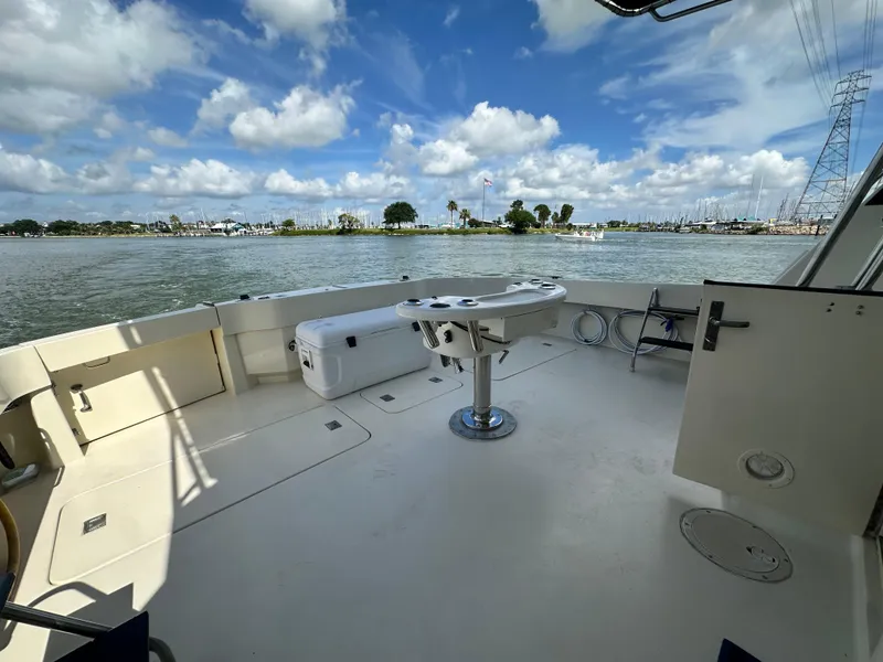 Slide: The Image of 1988 Hatteras Enclosed Bridge Sportfish boat deck with scenic waterfront view. - 20