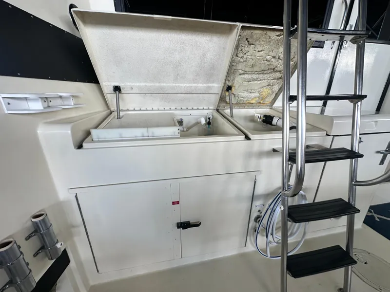 Slide: The Image of 1988 Hatteras Enclosed Bridge Sportfish interior with open storage compartments and ladder. - 27