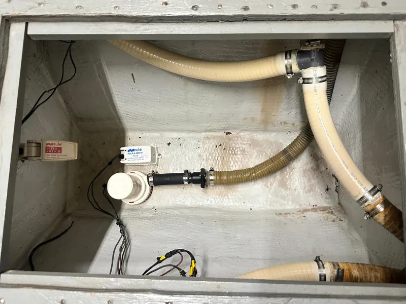 Slide: The Image of 1988 Hatteras Enclosed Bridge Sportfish bilge area with hoses and Rule switches. - 37