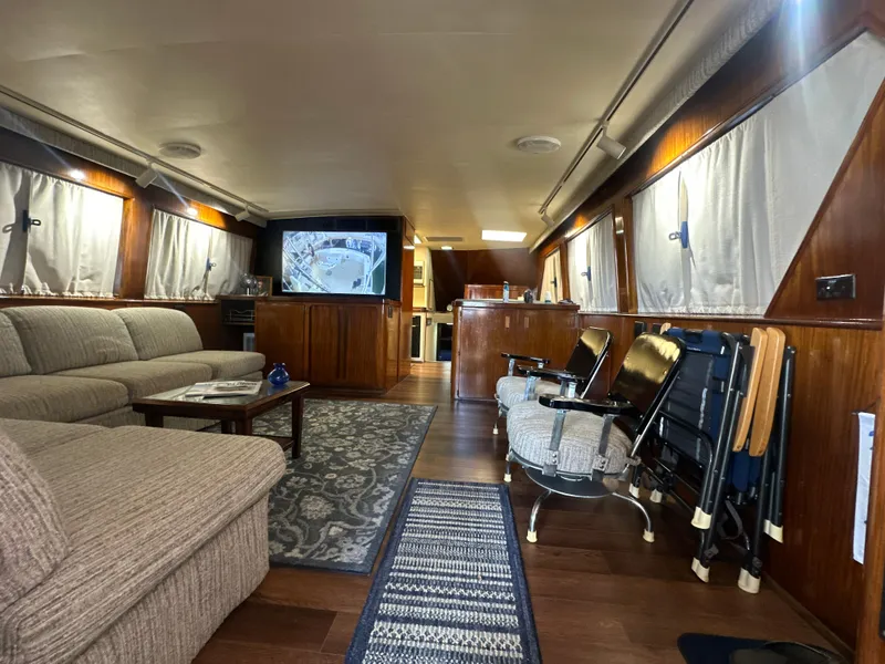 Slide: The Image of Luxurious interior of a 1988 Hatteras Enclosed Bridge Sportfish yacht with cozy seating and TV. - 38