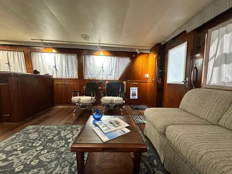 Slide: The Image of Interior of 1988 Hatteras Enclosed Bridge Sportfish with cozy seating and wooden accents. - 44