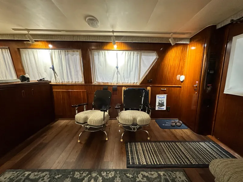 Slide: The Image of Interior of 1988 Hatteras Enclosed Bridge Sportfish with wooden paneling and seating. - 45