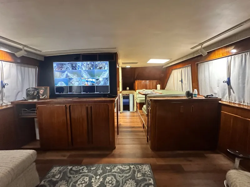 Slide: The Image of Interior of 1988 Hatteras Enclosed Bridge Sportfish with wood cabinetry and surveillance screens. - 47