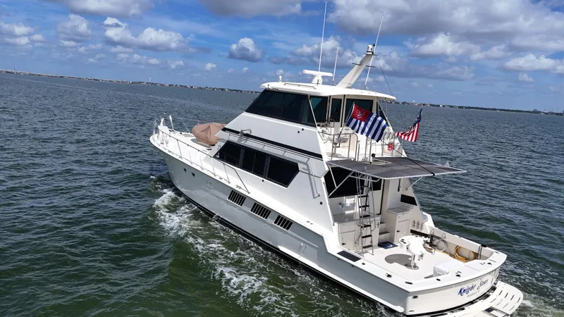Slide: The Image of 1988 Hatteras Enclosed Bridge Sportfish yacht cruising on open water under a partly cloudy sky. - 6