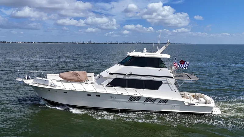 Slide: The Image of 1988 Hatteras Enclosed Bridge Sportfish yacht cruising on open water under blue skies. - 12
