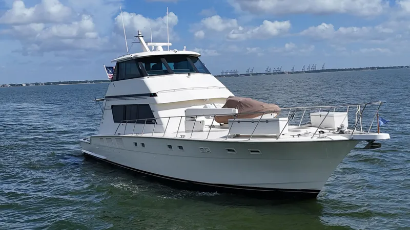 Slide: The Image of 1988 Hatteras Enclosed Bridge Sportfish yacht cruising on open water under blue skies. - 13
