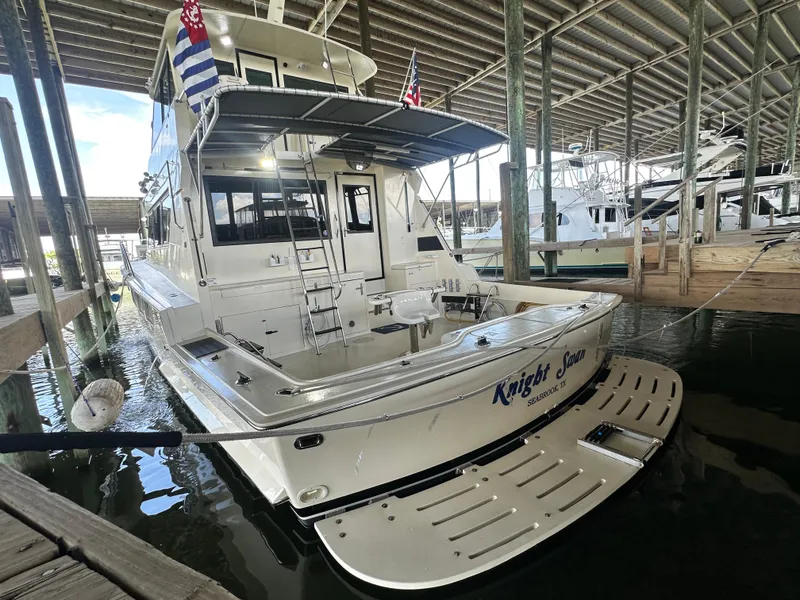 Slide: The Image of 1988 Hatteras Enclosed Bridge Sportfish yacht docked in a marina, rear view. - 17