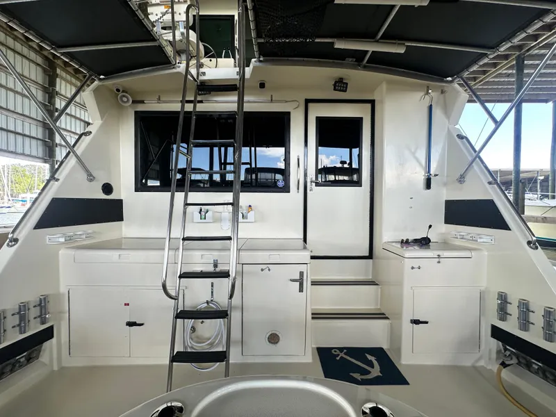 Slide: The Image of 1988 Hatteras Enclosed Bridge Sportfish boat interior with ladder, storage, and fishing equipment. - 19