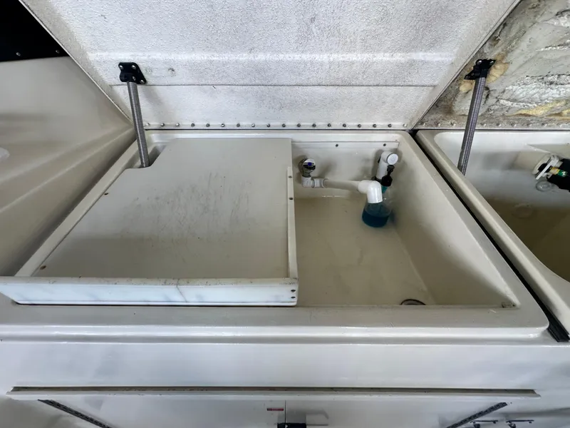 Slide: The Image of 1988 Hatteras Enclosed Bridge Sportfish sink with cleaning supplies and open lid. - 28