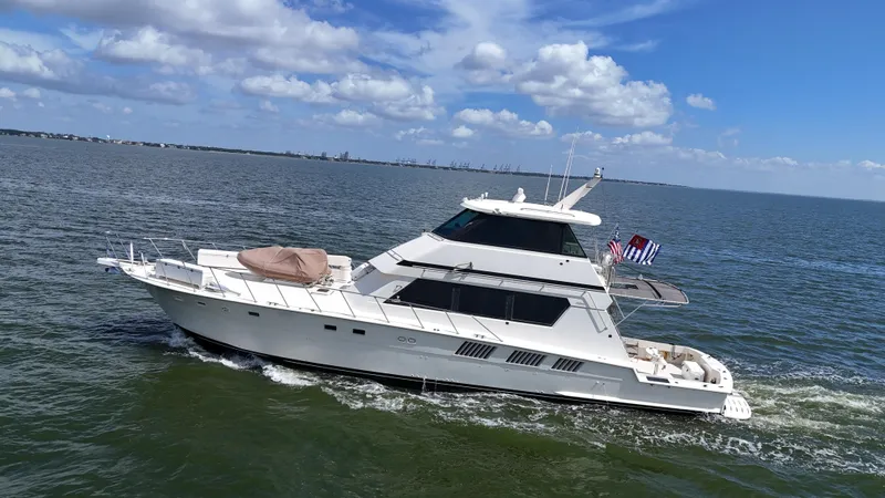 Slide: The Image of 1988 Hatteras Enclosed Bridge Sportfish yacht cruising on open water under blue skies. - 4
