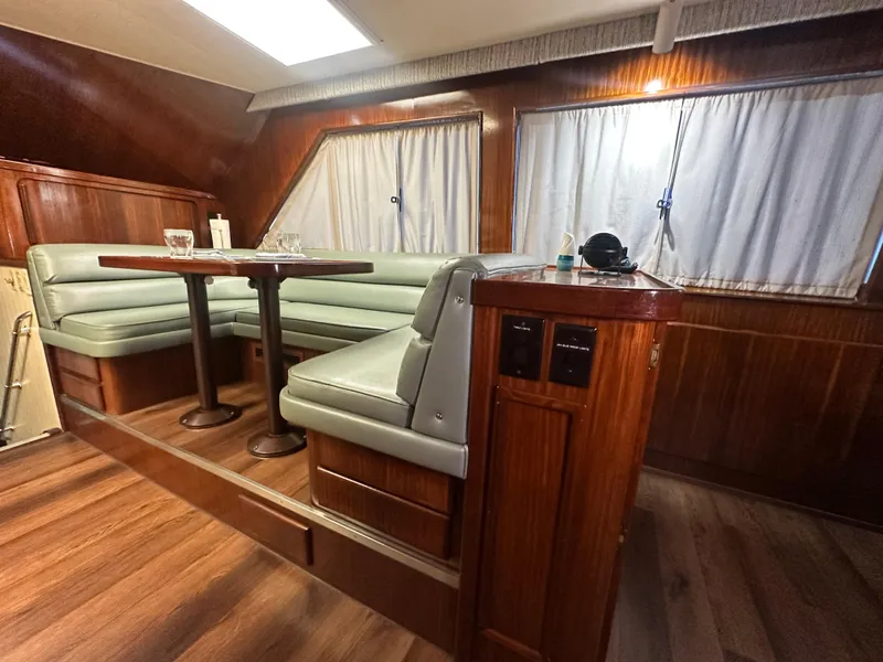 Slide: The Image of 1988 Hatteras Enclosed Bridge Sportfish interior with wood paneling and dining area. - 49