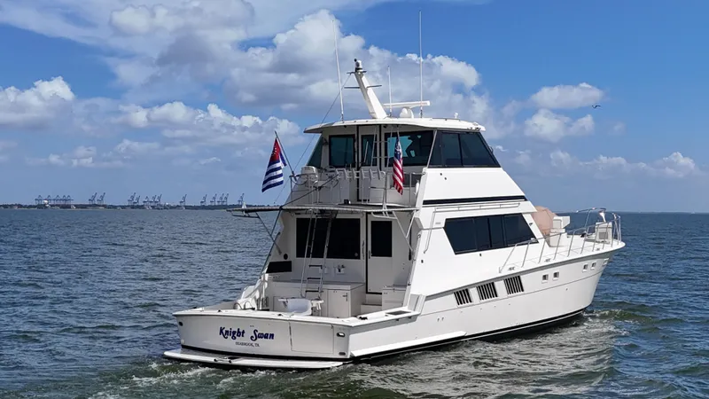 Slide: The Image of 1988 Hatteras Enclosed Bridge Sportfish yacht cruising on open water under a blue sky. - 7