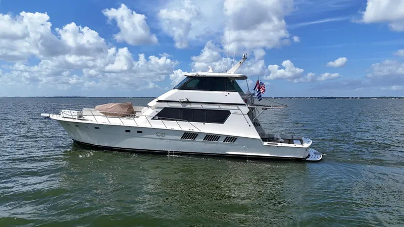 Slide: The Image of 1988 Hatteras Enclosed Bridge Sportfish yacht on open water under a cloudy sky. - 9