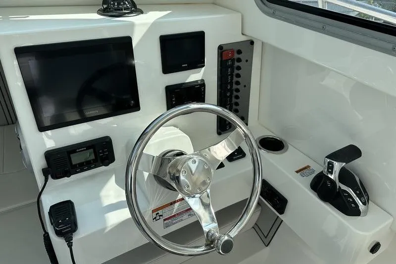 Slide: The Image of 2026 Parker 2220 SPORT CABIN helm with steering wheel, controls, and navigation screens. - 20
