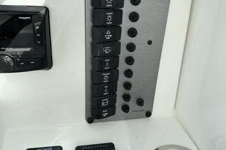 Slide: The Image of Control panel of 2026 Parker 2220 SPORT CABIN boat with labeled switches and display. - 22