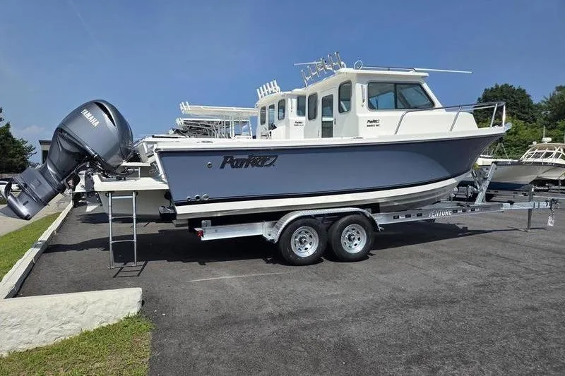 Slide: The Image of 2026 Parker 2220 Sport Cabin boat on trailer, featuring Yamaha outboard motor. - 5