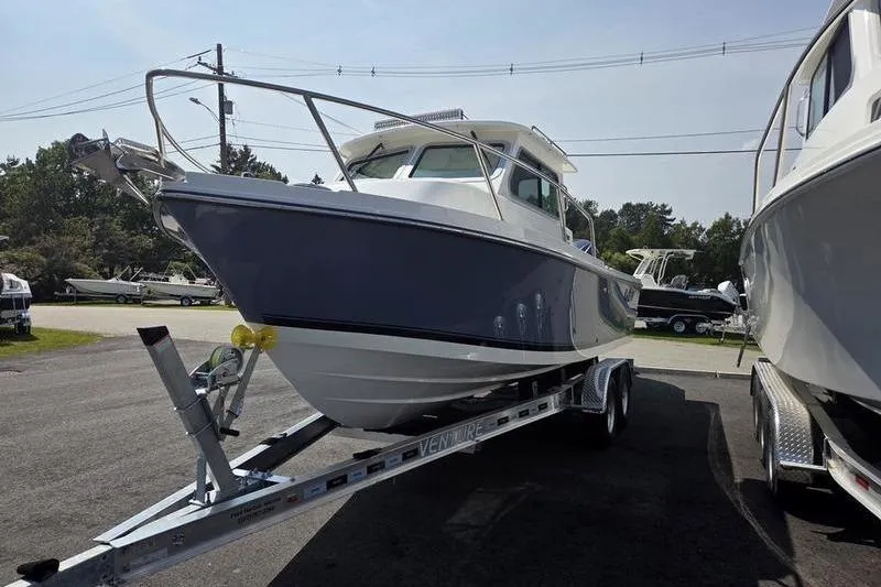 Slide: The Image of 2026 Parker 2220 Sport Cabin boat on trailer, parked outdoors. - 7