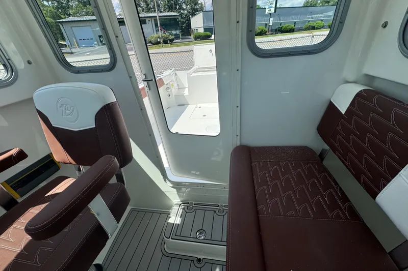 Slide: The Image of Interior of 2025 Parker 2220 SC boat with brown seating and open door. - 11