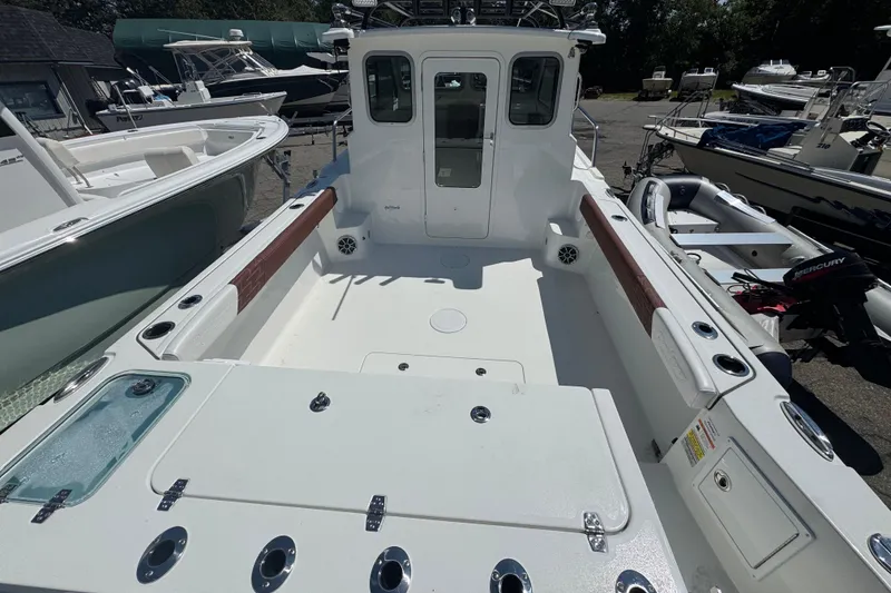 Slide: The Image of 2025 Parker 2220 SC boat interior, spacious deck, rod holders, and storage compartments. - 15