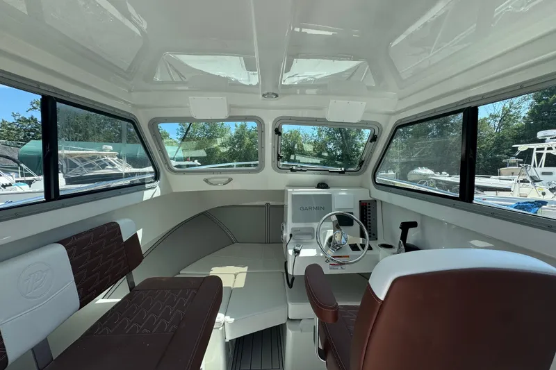 Slide: The Image of Interior of 2025 Parker 2220 SC boat with Garmin navigation system and brown seating. - 3