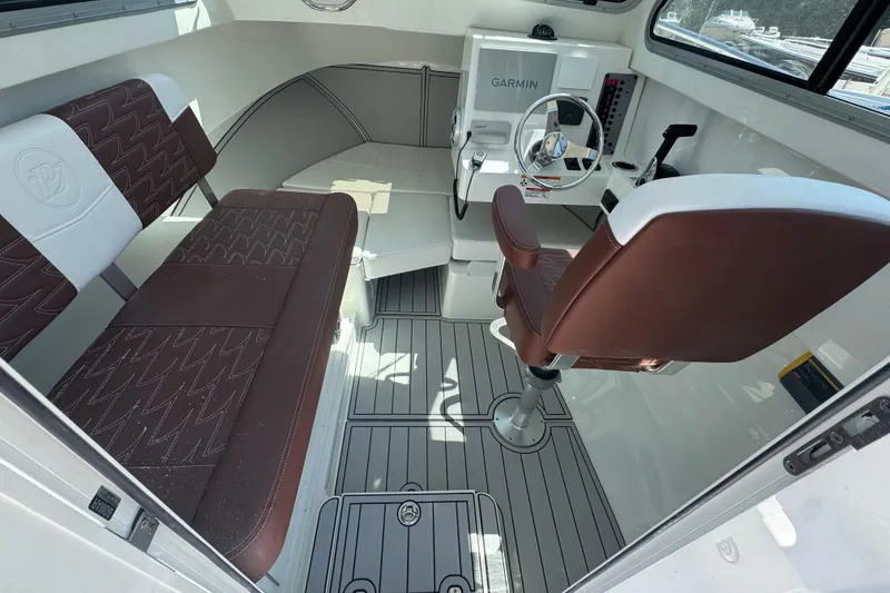 Slide: The Image of 2025 Parker 2220 SC boat interior with brown seating and Garmin navigation system. - 5