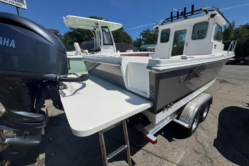 Slide: The Image of 2025 Parker 2220 SC boat on trailer with Yamaha outboard motor, parked outdoors. - 6