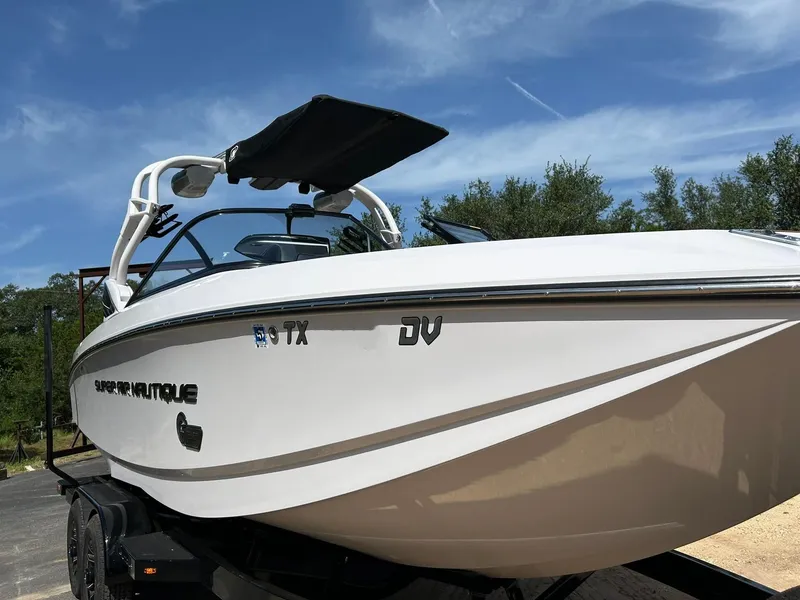 Slide: The Image of 2014 Nautique Super Air Nautique G23 boat on trailer under clear blue sky. - 10