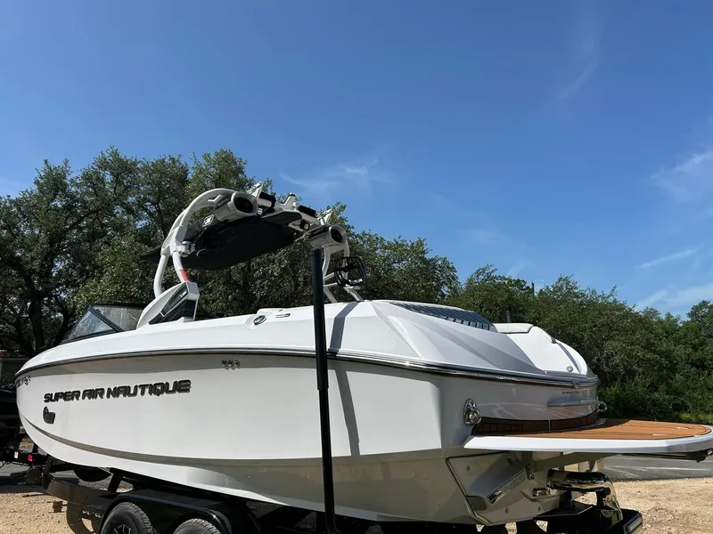 Slide: The Image of 2014 Nautique Super Air Nautique G23 boat on trailer, outdoors under clear blue sky. - 15