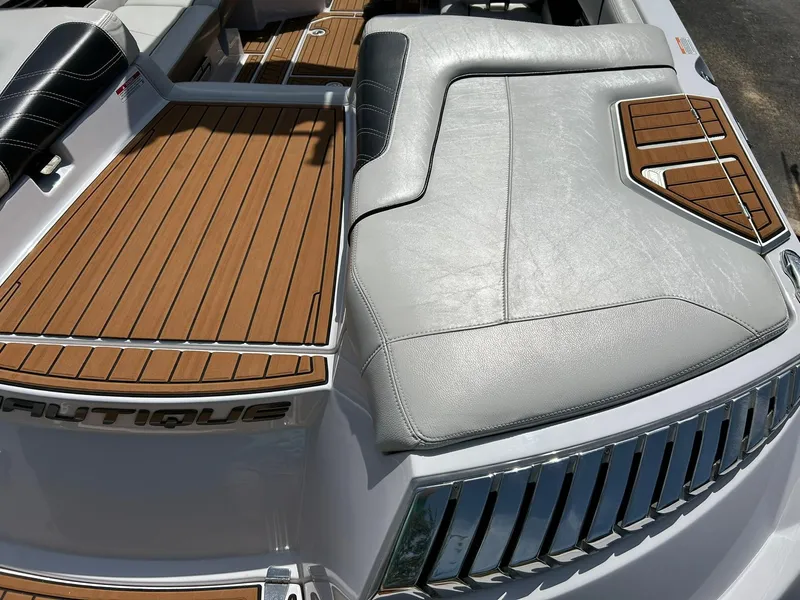 Slide: The Image of 2014 Nautique Super Air Nautique G23 boat interior with teak flooring and cushioned seating. - 32