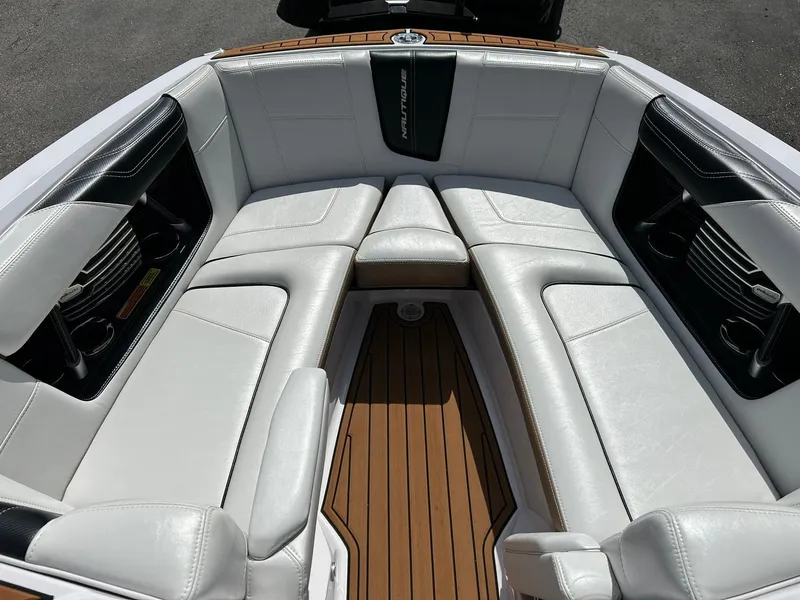 Slide: The Image of 2014 Nautique Super Air Nautique G23 boat interior with white leather seating and wood flooring. - 4