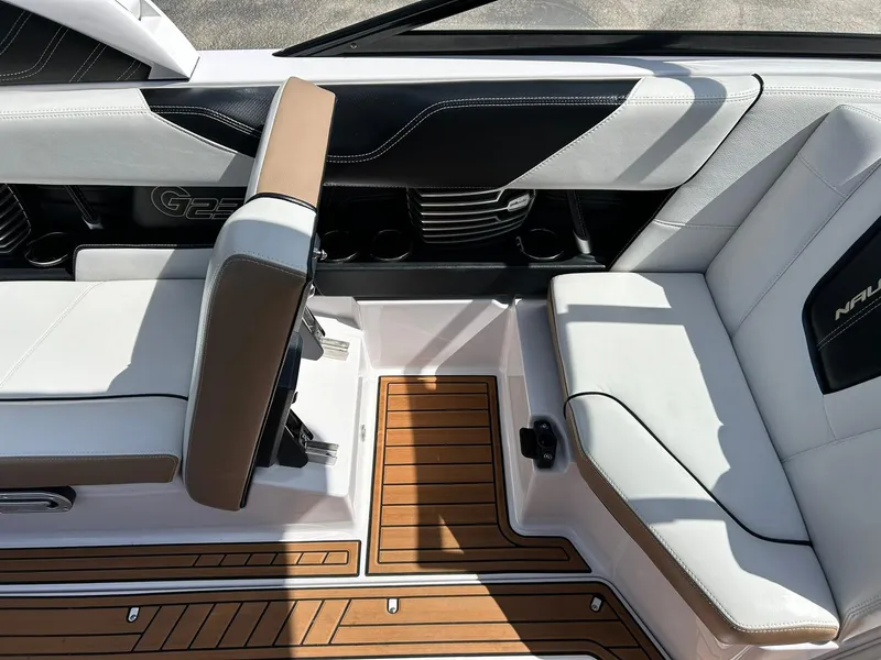 Slide: The Image of 2014 Nautique Super Air Nautique G23 interior with white and tan seating, teak flooring. - 47