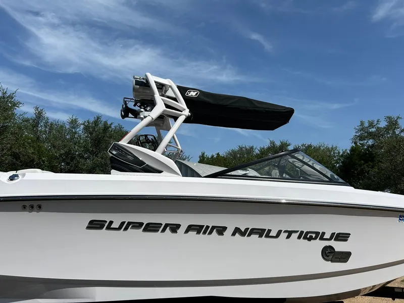 Slide: The Image of 2014 Nautique Super Air Nautique G23 boat under clear blue sky. - 7