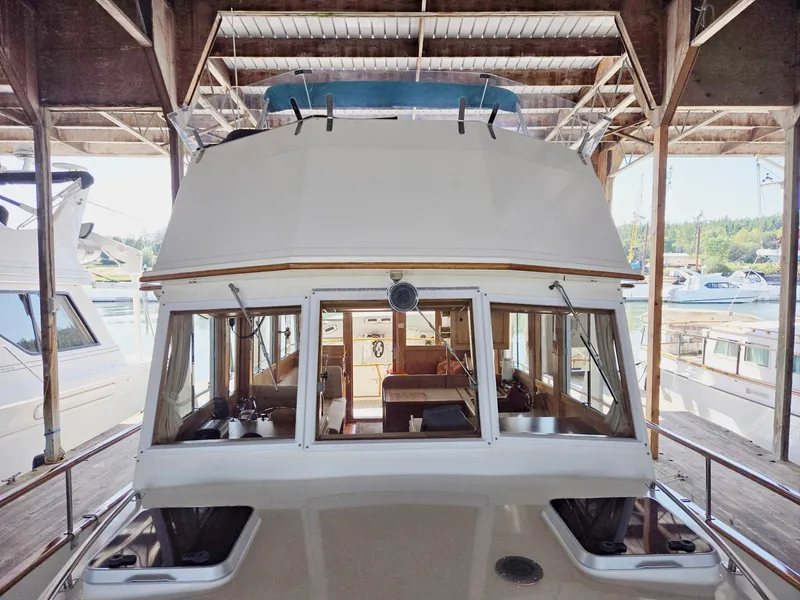 Slide: The Image of 1990 Grand Banks 36 Europa yacht docked under a wooden shelter. - 12