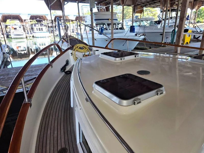 Slide: The Image of 1990 Grand Banks 36 Europa yacht docked in a marina, showcasing deck and hatches. - 14
