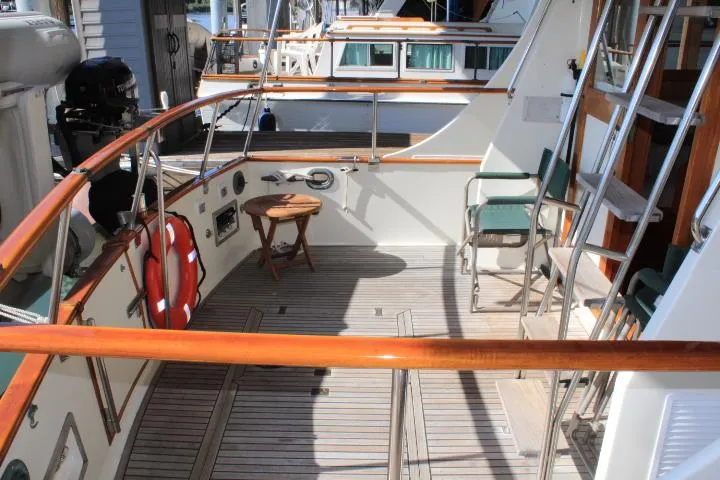 Slide: The Image of 1990 Grand Banks 36 Europa yacht deck with wooden railings and seating area. - 18
