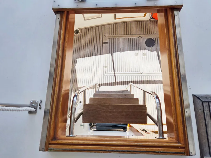 Slide: The Image of Staircase view inside 1990 Grand Banks 36 Europa yacht, featuring wooden and metal details. - 24