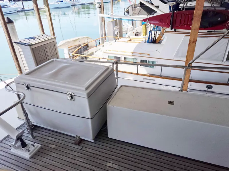 Slide: The Image of Deck view of 1990 Grand Banks 36 Europa yacht with storage boxes and marina background. - 35