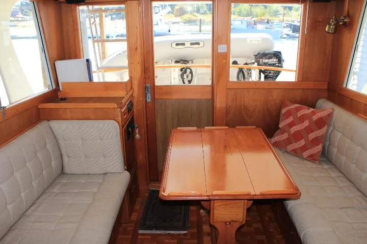 Slide: The Image of Interior of 1990 Grand Banks 36 Europa yacht with wooden table and cushioned seating. - 39