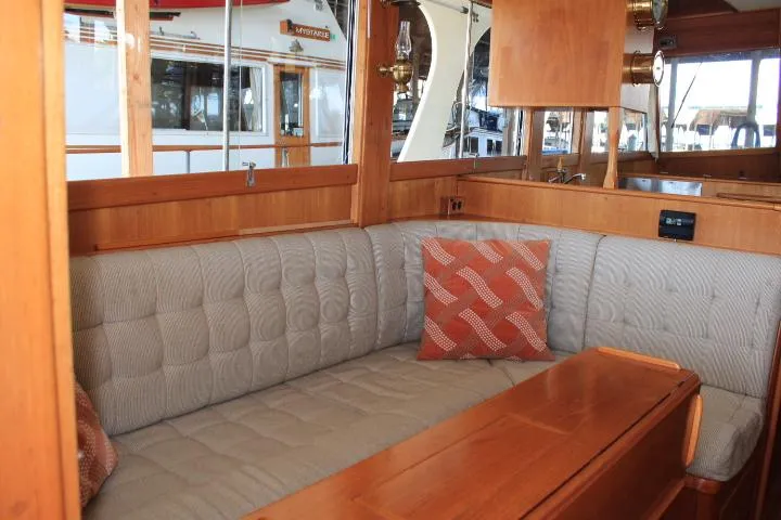 Slide: The Image of Cozy interior of 1990 Grand Banks 36 Europa yacht with cushioned seating and wooden accents. - 41
