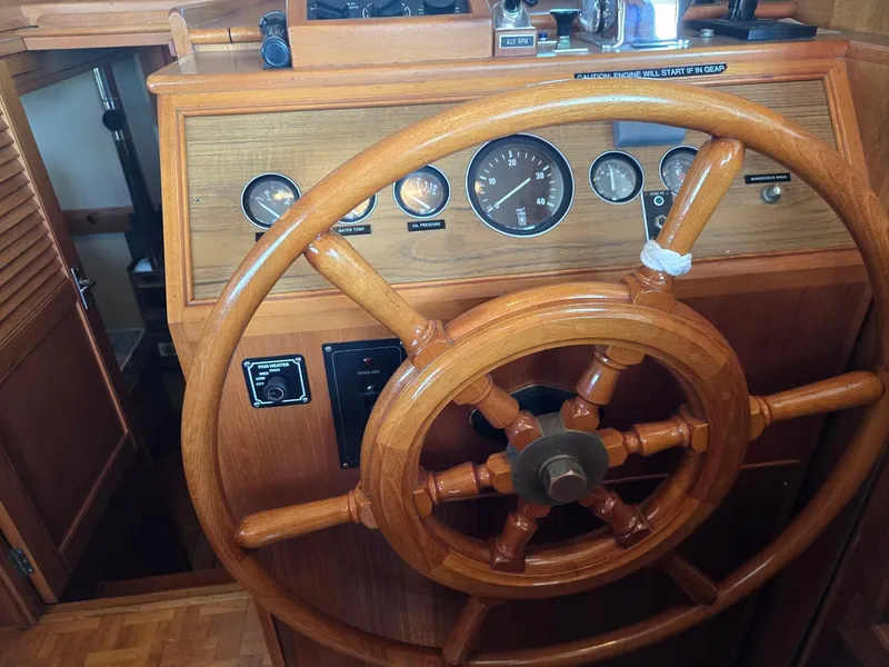 Slide: The Image of Wooden helm of a 1990 Grand Banks 36 Europa boat with gauges and controls. - 49